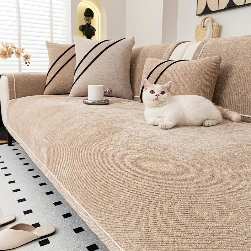 Vit katt ligger på ett sandbeige soffskydd i chenille